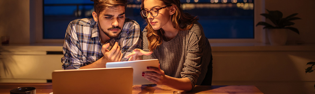 Young couple sitting at table going over their finances. 