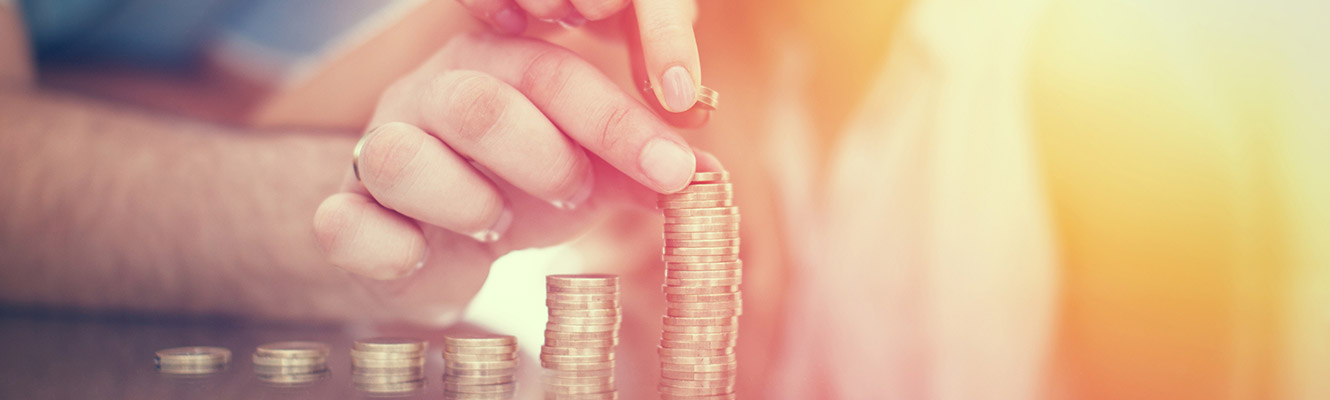 Couples hands counting pennies and putting them in stacks. 