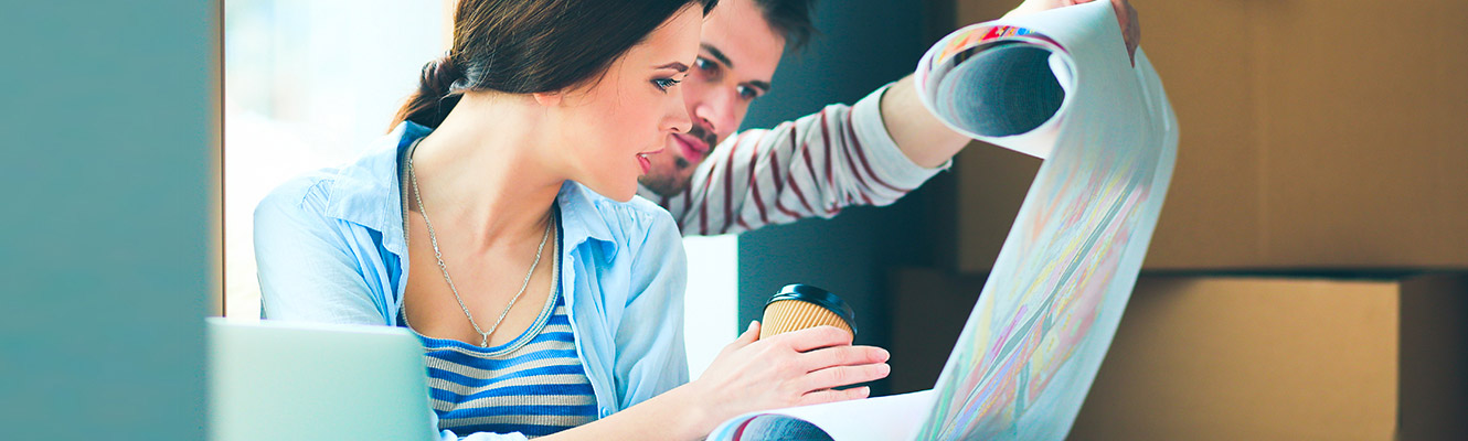 Young couple looking over blueprints together. 