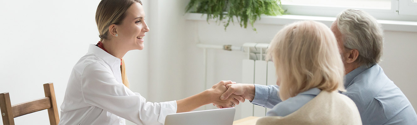 Young woman shaking hands with older man. 