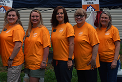 Enrichment employees stand together at Habitat For Humanity home being built.