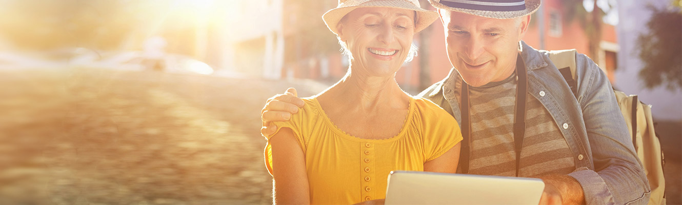 Older couple outside looking at tablet.