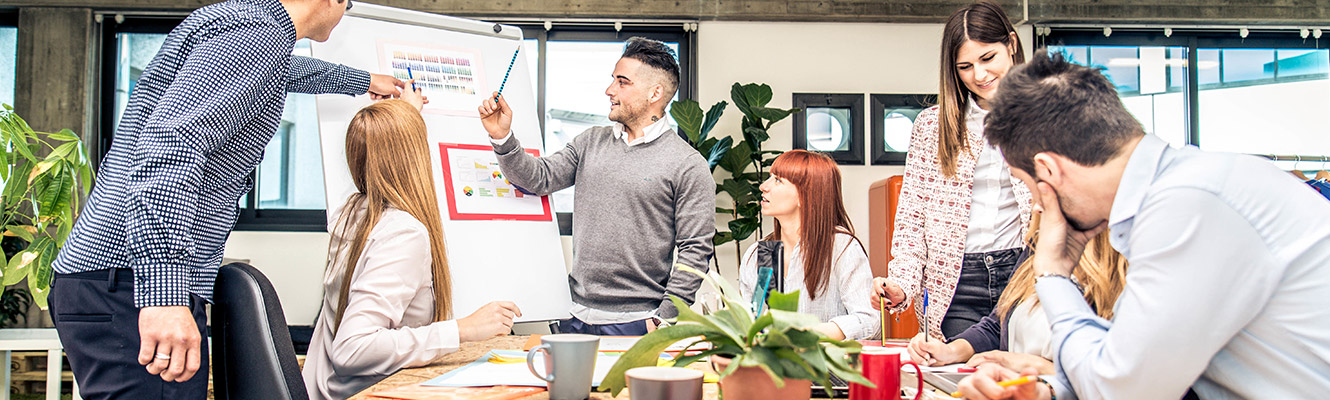 Group of individuals discussing business charts.