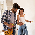 Young couple measuring in new home construction.