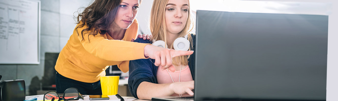 Two woman looking at computer. 