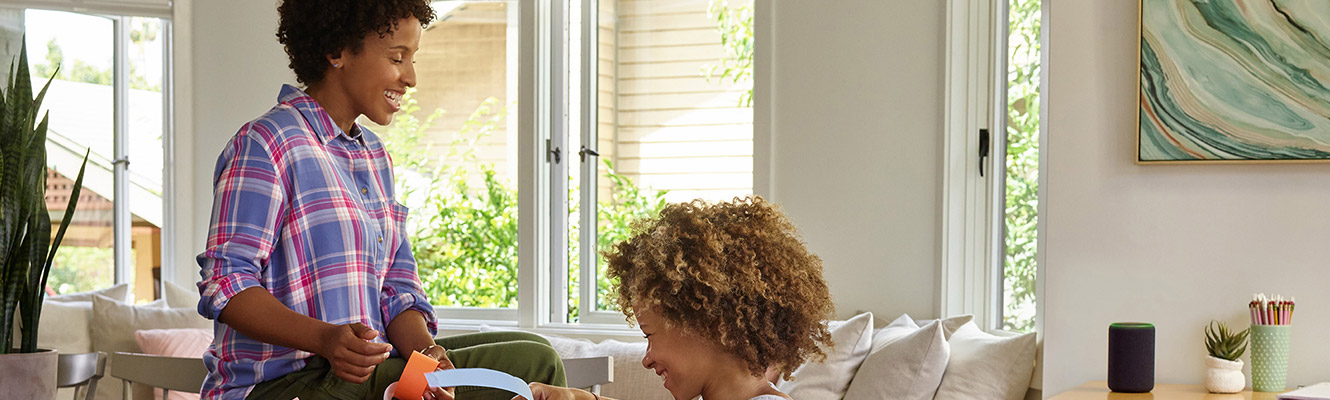 Mom and daughter in living room with Amazon Echo.