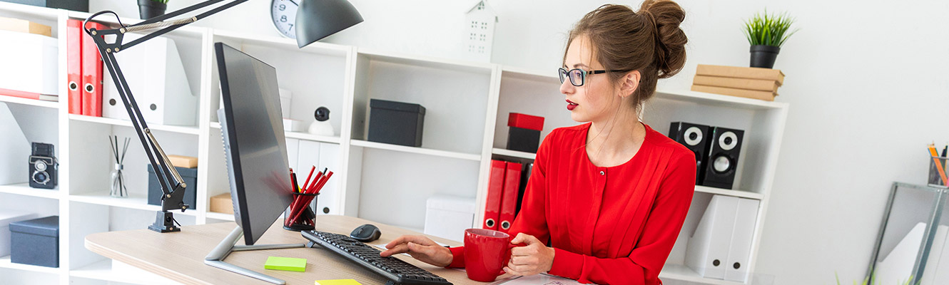 Woman sitting at a desk working on the computer.